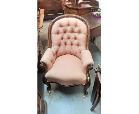 Victorian mahogany armchair with buttoned pink upholstery on cabriole front legs and ceramic castors