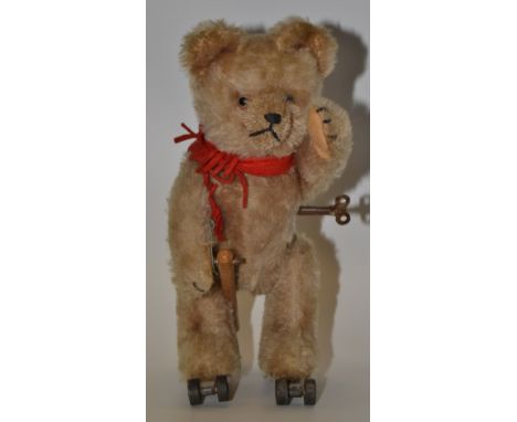 A Schuco Rolly Teddy Bear, with blonde mohair, brown and black glass eyes, pronounced clipped muzzle, black stitched nose, mo