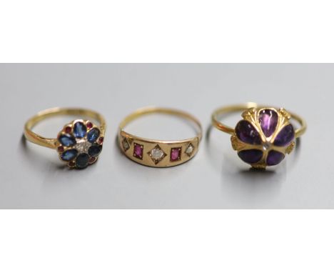 An 18ct, ruby, sapphire and diamond set circular cluster ring, size L, gross 3.2 grams, a yellow metal and foil backed amethy