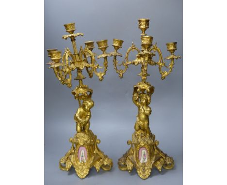 A pair of 19th century French ormolu 'cherub' candelabra, with porcelain plaques to base, height 47.5cm