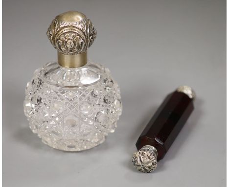 An Edwardian silver mounted glass toilet jar, 10.3cm and a white metal mounted ruby glass double scent bottle.