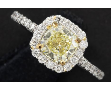 a 1,04 carat natural fancy yellow quality brilliant cut diamond set in a ring in white gold (18 carat) with circa 0,60 carat 