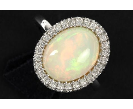 matching ring in white gold (18 carat) with a "full" cabochon cut opal surrounded by 0,81 carat of very high quality brillian