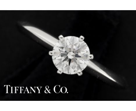 a Tiffany marked ring in platinum with a 0,76 carat high quality brilliant cut diamond with its box, poach and shop's bag wit