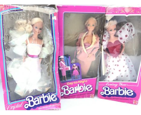 3 Boxed Barbies. A Crystal Barbie. A Day And Night Barbie and a Loving You Barbie. Boxes Are Worn.