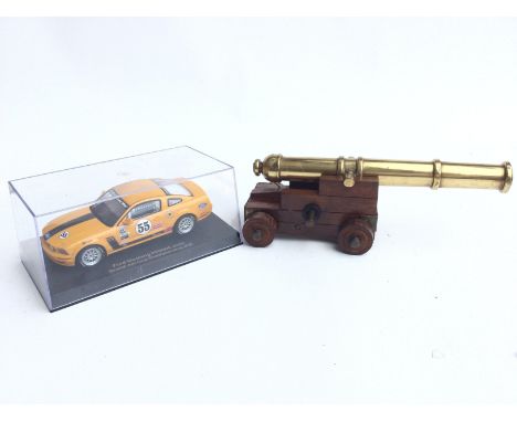 A Boxed Autoart Ford Mustang Slot Racing Car and a Small Model Cannon.