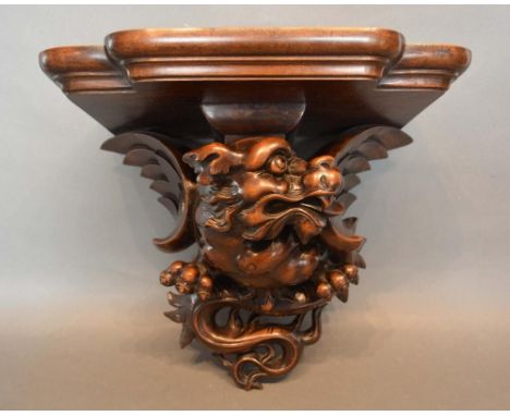 A Late 19th/Early 20th Century Chinese Hardwood Clock Bracket in the form of a winged serpent, 31cm long, 36cm wide 