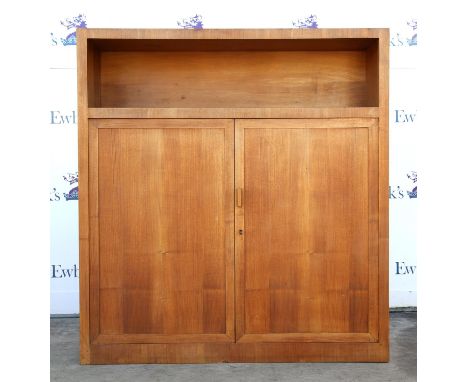 A German pearwood and oak rectangular cabinet, with vacant shelf above panelled doors, on plinth bases, the interior with v t