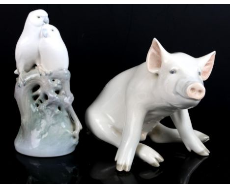 A Royal Copenhagen figure modelled as a seated pig No. 414, 16cm, group of 2 budgerigars sitting on a trunk No. 649 18cm