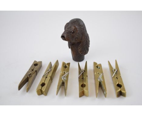 A collection of 6 brass clothes pegs, working order, with a carved wooden stick handle in the form of a dog's head, with movi