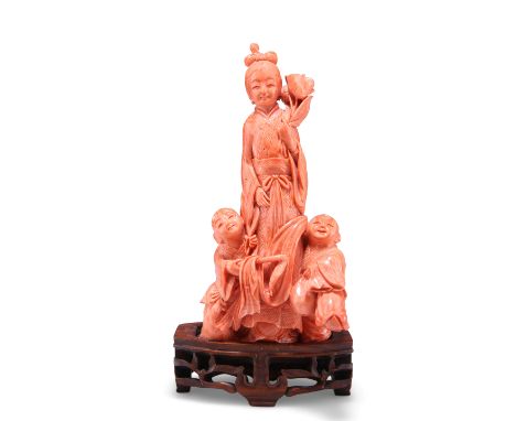 A 19TH CENTURY CHINESE FINE CORAL FIGURE GROUP,&nbsp;carved as&nbsp;a maiden in robes holding a flower with two boys at her f