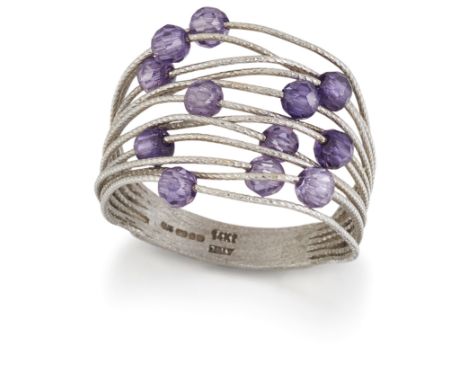 A 14 CARAT WHITE GOLD AMETHYST RING, twisted wires threaded with faceted amethyst beads. Hallmarked Birmingham 2006, ring siz