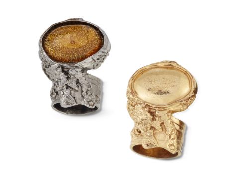 YVES SAINT LAURENT - TWO ARTY RINGS,&nbsp;one gilt, the other anodised and set with a yellow cabochon. Maker's mark, Ring siz