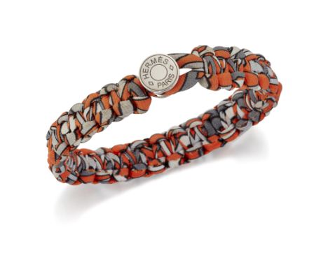 HERMÈS - A SILK TWILL KID BRACELET, of braided orange and grey silk, to a button closure. Signed 'Hermès Paris', 6cm inner di