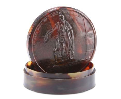 AN 18TH CENTURY TORTOISESHELL SNUFF BOX,&nbsp;circular, the cover pressed to depict a Classical figure and motto. 7.5cm diame