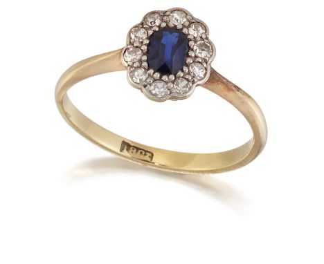 A SAPPHIRE AND DIAMOND CLUSTER RING, an oval-cut sapphire within a border of eight-cut diamonds, to knife-edge shoulders. Est