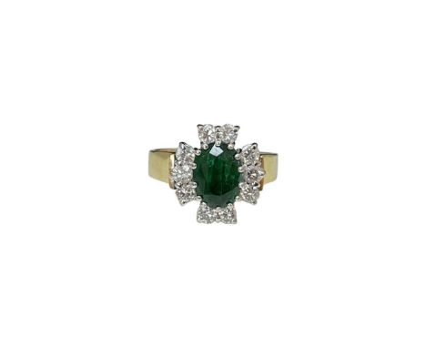 A emerald and diamond ring, the oval emerald surrounded by brilliant cut diamonds to a wide tapering shank, 18ct yellow and w