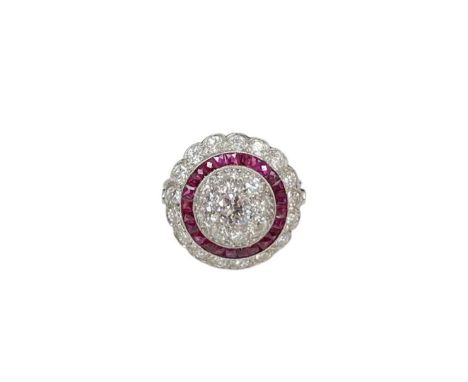 A ruby and diamond target ring, the central diamond cluster surrounded by calibre cut rubies, and surrounded by a further dia