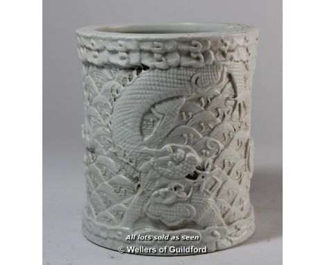 A Chinese cream cylindrical brush pot carved all over with dragons and scales, 12cm.