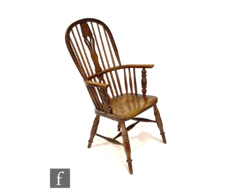 An early 20th Century ash and elm seat stick back Windsor elbow chair, on turned splayed legs united by turned stretchers. 