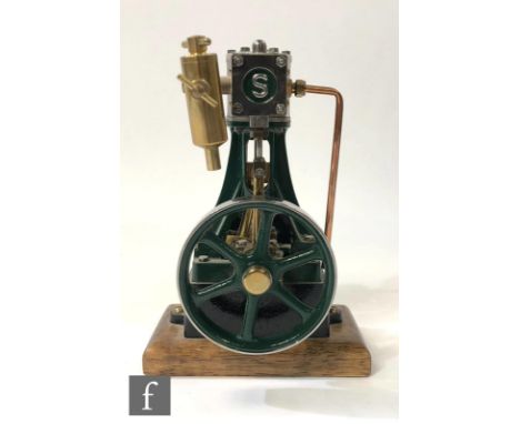 A Stuart single cylinder vertical live steam engine, painted green, with a six spoked flywheel, raised to a mahogany plinth, 