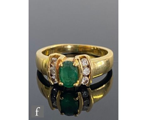 An 18ct hallmarked emerald and diamond three stone ring, central oval emerald flanked by three diamonds to either side, weigh