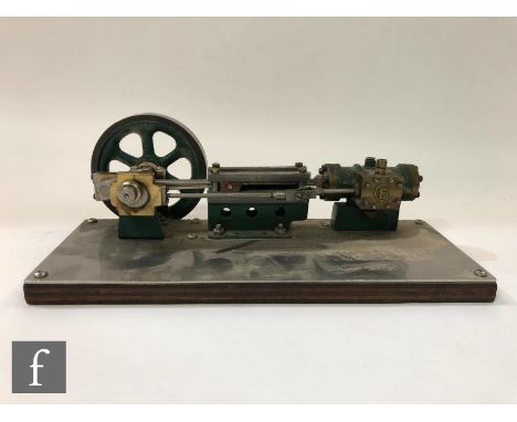 A single cylinder horizontal engine with six spoked flywheel, painted in green and raised to a steel and plywood base, length