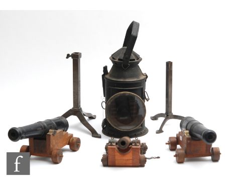 A hand held signal lamp, an adjustable trivet and three cast iron fire side canons with carriages. (5) 