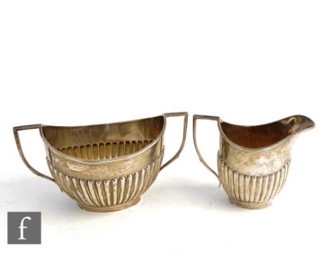 A hallmarked silver boat shaped cream jug and sugar basin each with part fluted decoration, total weight 11oz, Sheffield 1886