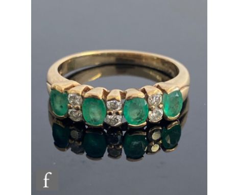 An 9ct hallmarked emerald and diamond ten stone ring, foue oval collar set emeralds space by three pairs of brilliant cut dia