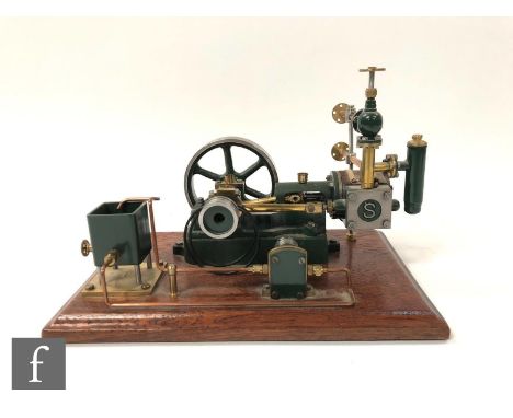 A Stuart single cylinder horizontal engine, with water tank and six spoked flywheel, raised to a wooden base, height 16cm, wi