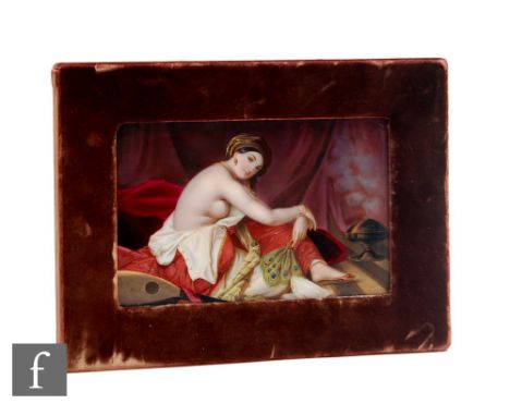 A late 19th Century hand painted KPM type porcelain plaque with a scene of a partially undressed lady holding a peacock feath