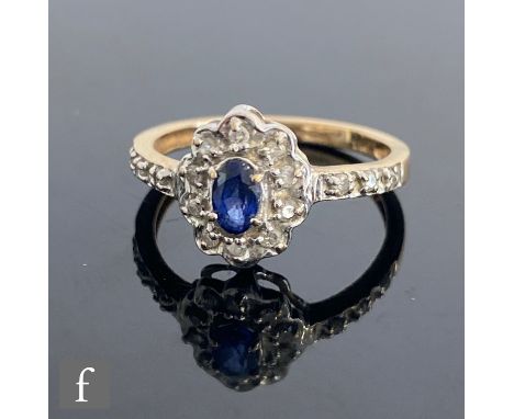 A 9ct hallmarked sapphire and diamond cluster ring, central oval sapphire within a ten stone diamond surround and diamond set