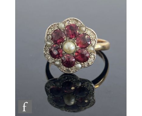 A 9ct split pearl, almandine garnet and diamond cluster ring, with six central garnets within a pearl and diamond daisy shape
