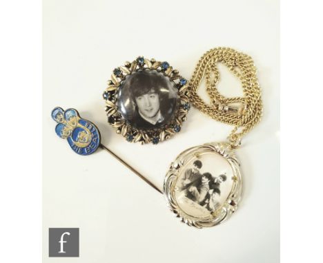 A small group of Beatles memorabilia to include a 1964 necklace pendant with a black and white group photo behind plastic dom