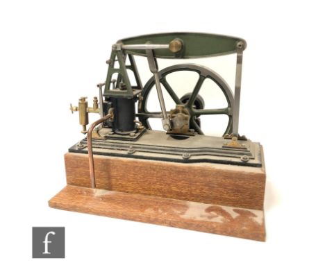 A Stuart horizontal beam live steam engine, with a six spoked green painted flywheel, diameter 18cm, raised to a mahogany pli