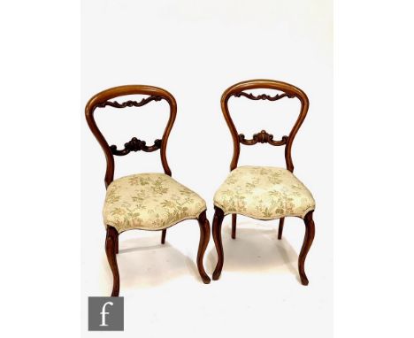 A set of four Victorian mahogany salon chairs, carved scroll splats, on cabriole legs, upholstered in printed floral tapestry