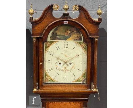 An early 19th Century oak longcase clock with an eight day movement striking on a bell, the case with twin swan neck pediment