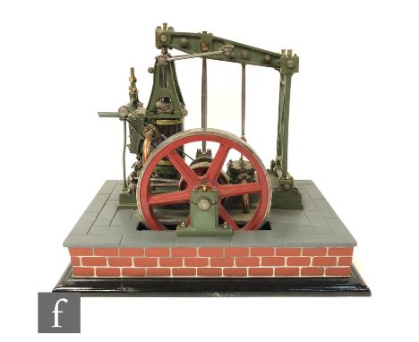 A scratch built beam engine with wooden cylinder and six spoked red flywheel, raised to a simulated slate stepped base, heigh