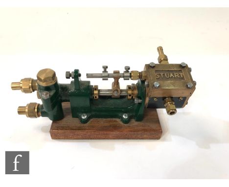 A Stuart horizontal single cylinder engine, painted in green and raised to a mahogany plinth, length 15.5cm. 