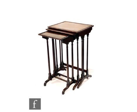 A nest of three Edwardian mahogany occasional tables on ring turned tapering supports, each united by a stretcher on shaped e