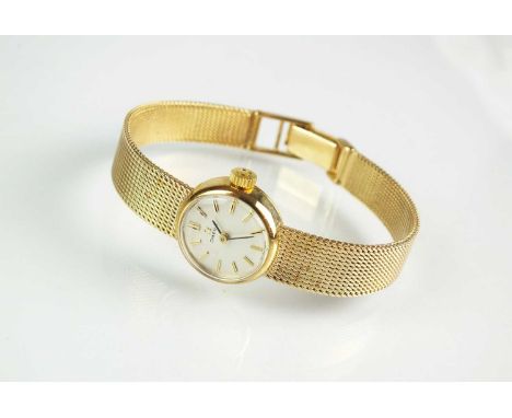 A 9ct gold lady's Omega bracelet watch, the circular silvered dial with batons, with integral 9ct yellow gold bracelet, manua