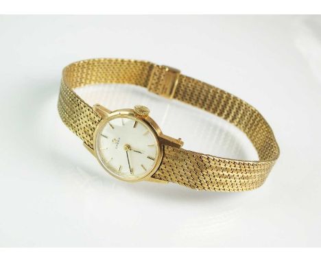 A 9ct gold Lady's Omega bracelet watch, the circular silvered dial with batons, with attached yellow gold bracelet strap, man