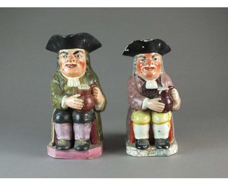 Two Staffordshire toby jugscirca 1820of 'ordinary type', modelled seating holding a plain brown salt glaze jug and a foaming 