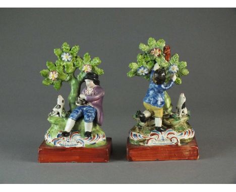 A pair of Staffordshire bocage figurescirca 1820modelled as a boy and his dog enticing a squirrel from a tree and a boy colle