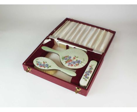 A cased four piece silver and enamel dressing table set, TP, London 1973 &amp; 1974, each with green-cream guilloche enamel g