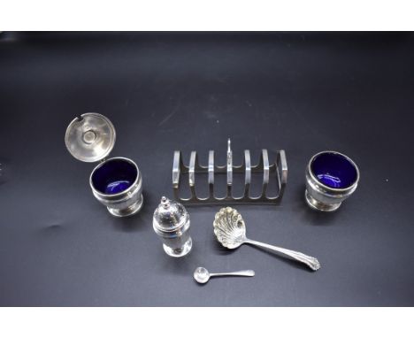 A silver three piece cruet set, by&nbsp;Fattorini &amp; Sons Ltd, Birmingham 1937; together with a silver six division toast 