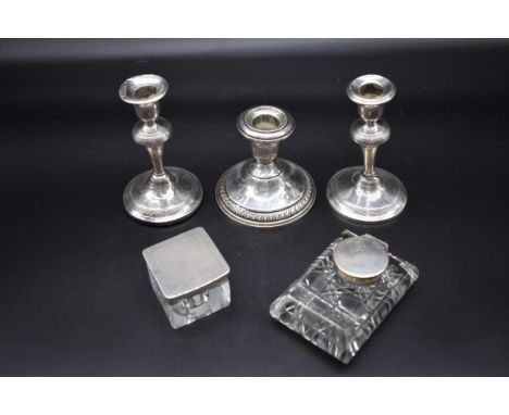 A pair of silver candlesticks; together with a sterling silver example; and two silver mounted glass inkwells. (5) 