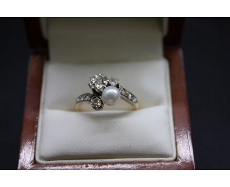 A yellow metal diamond and pearl crossover ring, the largest diamond approximately 0.5ct, size O. 