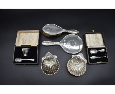 A quantity of silver,&nbsp;comprising: two cased christening sets; a silver hairbrush; a silver hand mirror; and a pair of si